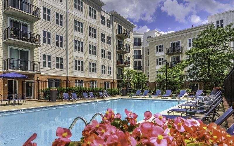 a swimming pool with chairs in a courtyard
