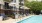 a pool with chairs and umbrellas by a building