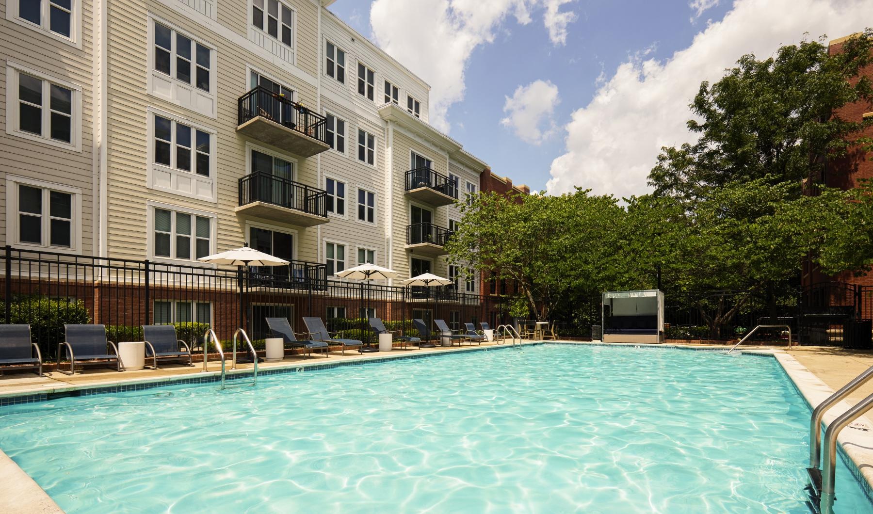 Relax and unwind poolside a swimming pool in front of a building